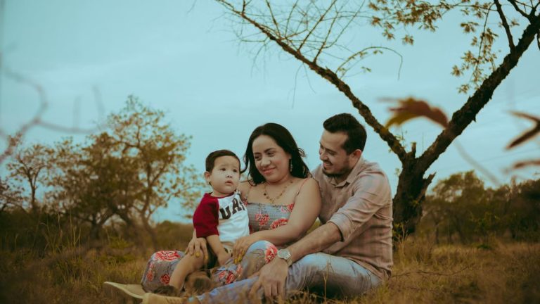 A family of three enjoying bonding time outdoors in a serene natural setting.